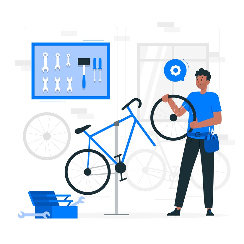Image représentant une personne en train de changer une roue de vélo. On voit une boite à outils et des outils au mur.