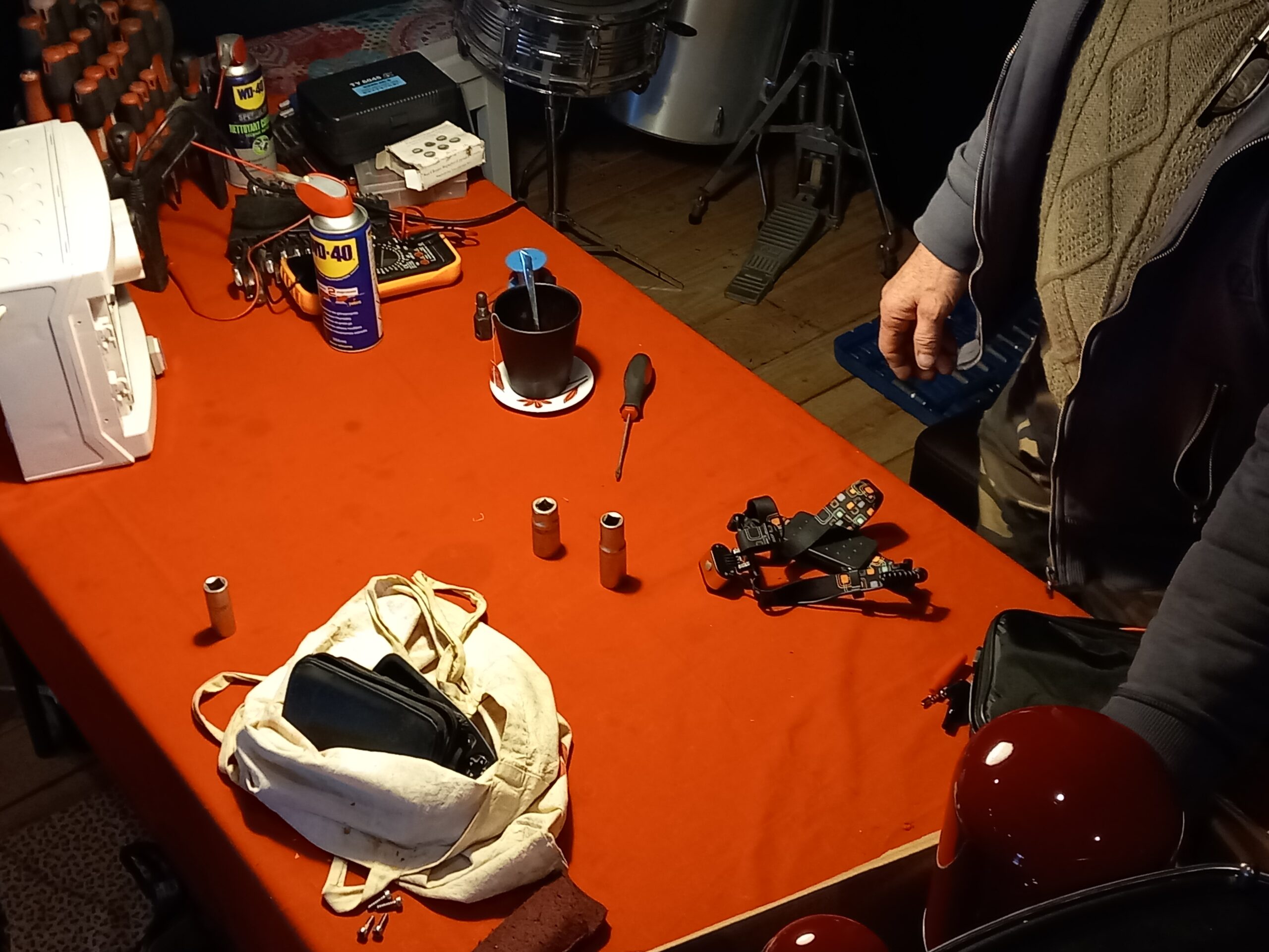 Photo représentant la table du répare café. On y voit divers outils : douilles de clé à cliquet, tournevis, WD-40.